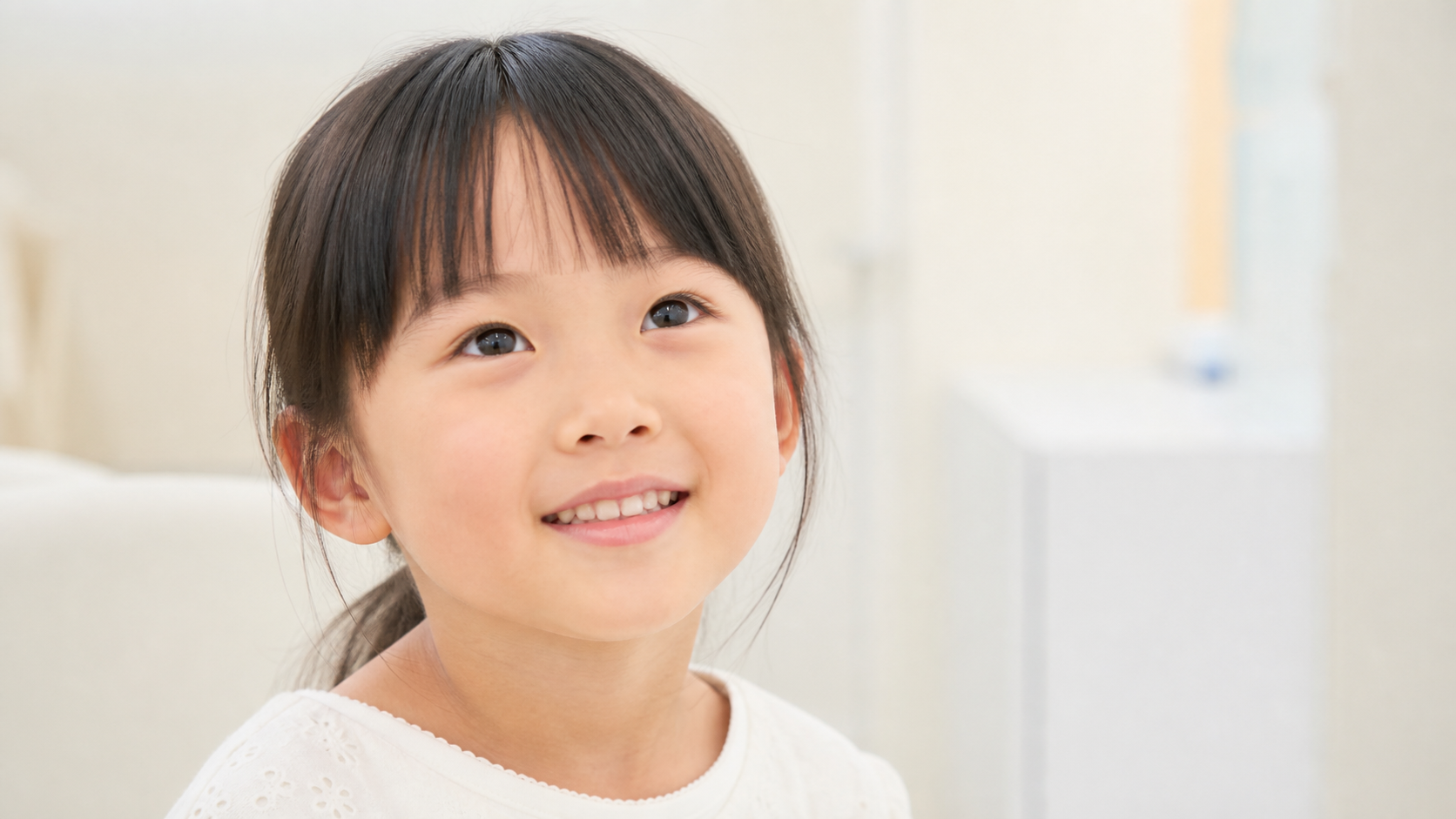 上を見上げて微笑むお子さま